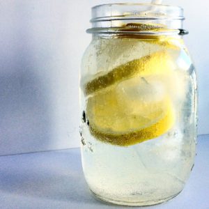 a jar filled with lemon soda and lemons